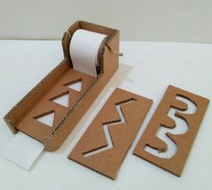 two cardboard boxes with cut out letters and a roll of toilet paper