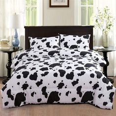 a black and white cow print comforter on a bed