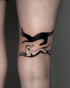 a woman's legs with a tattoo of a running dog