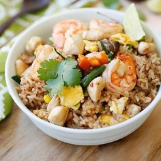 a white bowl filled with rice, shrimp and cilantro garnished with cilantro