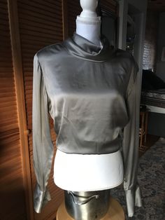 Vintage Jones New York 100% silk silver blouse; button closure up back with fold over draped turtleneck; size 10 Chic Silk High Neck Top, Chic High Neck Silk Top, Elegant High Neck Silk Top, Elegant High Neck Satin Top, Fitted High Neck Blouse For Fall, Elegant Turtleneck Top For Night Out, High Neck Evening Blouse For Fall, Silk High Neck Top For Evening, Elegant Turtleneck Top For Evening