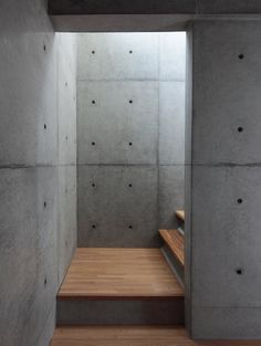 a wooden bench sitting inside of a cement building