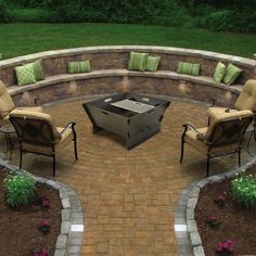 an outdoor fire pit surrounded by chairs and flowers in the middle of a brick patio