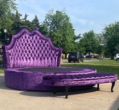 a purple bed sitting on top of a sidewalk