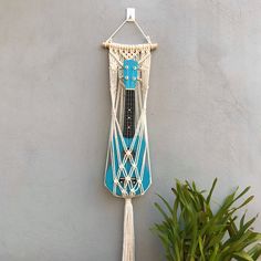 a macrame hanging on the side of a wall with a guitar in it