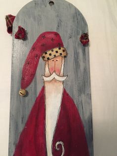 a wooden plaque with a painting of a santa clause