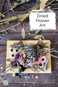 dried flower art is displayed on a wooden surface with the words dried flower art above it