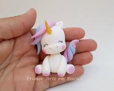 a tiny toy unicorn sitting in someone's hand