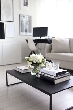 a coffee table with books and flowers on it