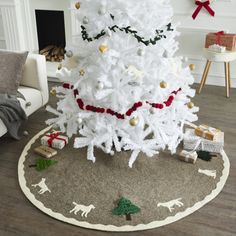 a white christmas tree in a living room with presents on the floor next to it