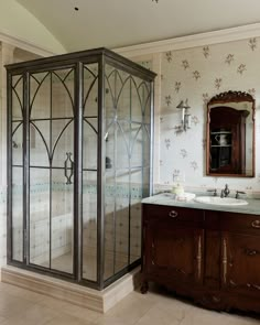 a bathroom with an enclosed shower next to a sink