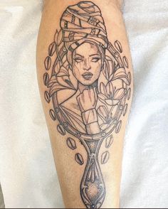 a tattoo on the leg of a woman with an hourglass in her hand and coffee beans around her head