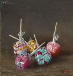 three lollipops wrapped in cellophane and tied with twine on sticks