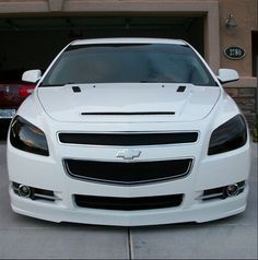 a white car parked in front of a garage