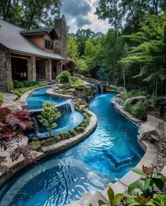 an outdoor swimming pool surrounded by trees and rocks, with a waterfall in the middle