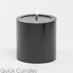 a black candle is lit on a white background