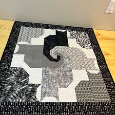 a black and white quilt on top of a wooden table