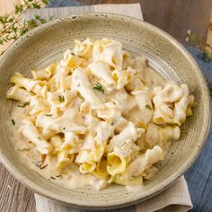 a bowl filled with macaroni and cheese on top of a wooden table