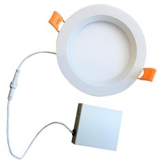 a white ceiling light with an orange cord connected to it and a small square piece of paper on the side