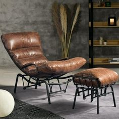 a brown leather chair and ottoman in a living room