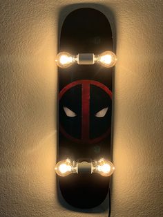 a skateboard with two lights on it is shown in the shape of a deadpool