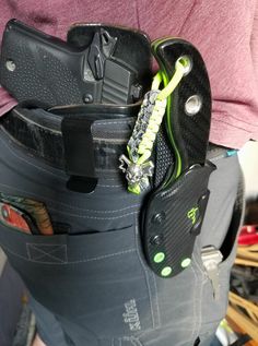 the inside of a pair of pants that has some tools in it and is being held by someone's back