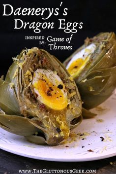 an egg is in the middle of some artichokes on a white plate