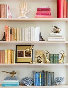 a book shelf filled with books next to a clock and other items on top of it