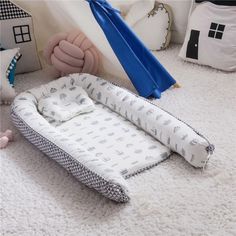 a baby's bed and pillows on the floor