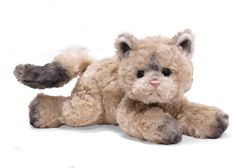 a stuffed animal cat laying down on the ground with its paws out and eyes wide open