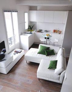 a living room filled with furniture and a flat screen tv sitting on top of a hard wood floor