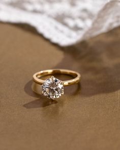 a diamond ring sitting on top of a sandy beach