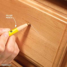 a person is holding a pencil in their left hand and pointing to the bottom of a drawer