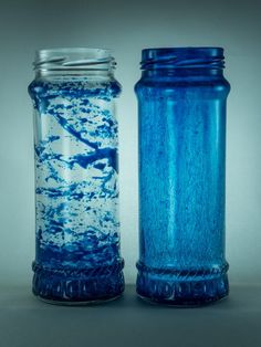 two blue glass jars sitting next to each other