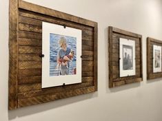 three wooden frames hanging on the wall with pictures attached to them, one holding a baby