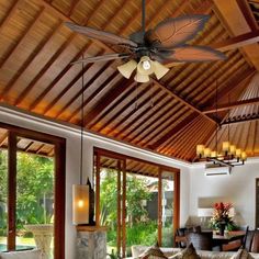 a living room filled with lots of furniture and a ceiling fan above the couches