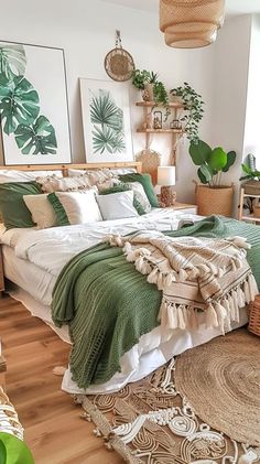 a bed with green blankets and pillows on top of it in a room filled with potted plants