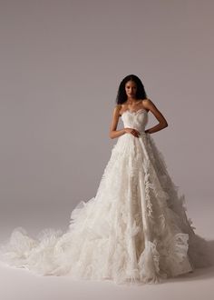 a woman in a white wedding dress posing for a photo with her hands on her hips