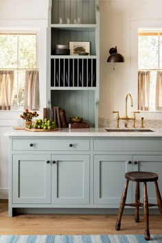 a kitchen with blue cabinets and wooden stools