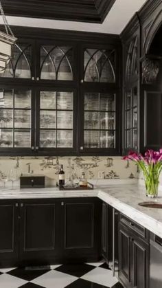 a black and white checkered floor kitchen with glass front cabinets, marble counter tops, and chandelier