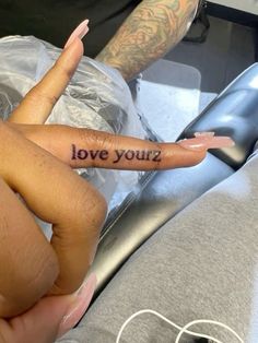 a person with a tattoo on their finger saying love you