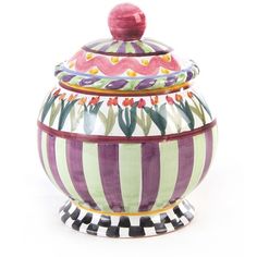 a colorful striped jar with a lid on it's side and flowers painted on the inside