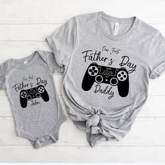 Level up your Father's Day celebration with our special collection of matching tees, designed exclusively for first-time gaming dads and their little players! Introducing our "Our First Father's Day Together" shirts, crafted with love to commemorate this milestone occasion. 👕 Our matching tees aren't just a fashion statement; they're a symbol of the unique bond between a new dad and his precious player two. Made with soft, high-quality materials, these shirts are perfect for creating lasting me Cotton T-shirt For Game Day And Father's Day, Cotton T-shirt For Game Day On Father's Day, Family Matching Cotton T-shirts For Game Day, Gamer Style Cotton T-shirt With Letter Print, Gamer Tops With Letter Print, Cotton T-shirt With Letter Print For Gaming Events, Father's Day Games, Gaming Tees, Personalized Matches