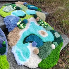 a pile of rugs sitting on top of a cement floor next to grass and bushes