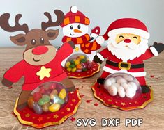 three paper santa clauss with candy in their hands and one reindeer holding a bag