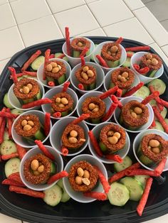 a platter filled with carrots, celery and nuts on top of cucumbers