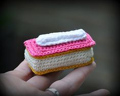 a small crocheted object in the palm of someone's hand that is holding it