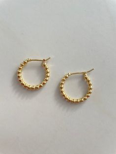 Gold bead hoop earrings. Beads hug the shape making a classic hoop. Earrings measures approximately 3/4” 14kt Gold vermeil, lead and nickel free Each piece is unique in color and may vary from the picture