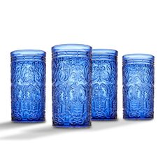 four blue glass cups sitting next to each other