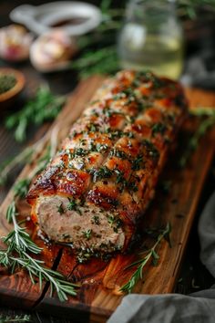 Roast pork loin garnished with rosemary on a wooden serving board. Bake Pork Loin Oven, Herb Crusted Pork Loin Roast, Pork Loin Thanksgiving, Parmesan Crusted Pork Loin, Marinade Pork Loin, Herb Stuffed Pork Loin, Pork Tenderloin Stuffed With Stuffing, Holiday Pork Roast Recipes, Roast Pork Loin Recipes